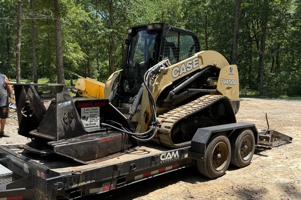 Case skid steer on trailer ready for transport to job site